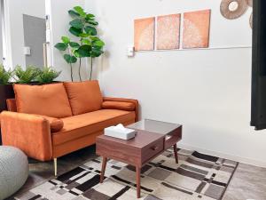 隠れ宿 藤 Private Inn Fuji - 足利駅5分の一棟貸切のお宿 في أشيكاغا: غرفة معيشة مع أريكة وطاولة قهوة