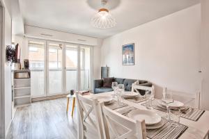 a dining room with a table and chairs and a couch at 2 Bedrooms, TV & Wifi in Villers-sur-Mer
