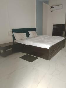a bed in a room with a white floor at Hotel Krishna Rooms in Jāmb