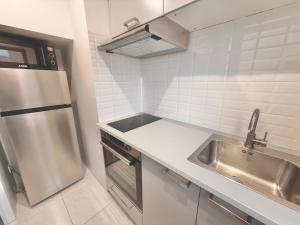 a kitchen with a sink and a stainless steel refrigerator at 2 Bedrooms, TV & Wifi in Villers-sur-Mer +1 photo