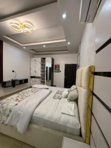 a bedroom with a large bed and a ceiling fan at Quantum Havens Apartment - Amsterdam in Akure