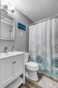 a bathroom with a toilet and a shower curtain at Wellness Retreat - Oceanfront condo w beach access in Ponte Vedra Beach