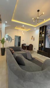 a large couch in a living room with a table at Quantum Havens Apartment - Amsterdam in Akure
