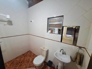 een badkamer met toilet en wastafel bij Canto do Atlântico in Ilha Comprida +30 foto's