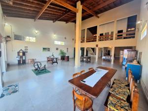 een grote kamer met een houten tafel en stoelen bij Canto do Atlântico in Ilha Comprida
