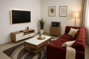 a living room with a red couch and a tv at CJ Apartment in Kasoa