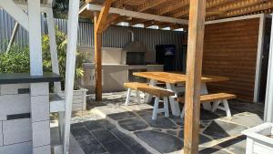 a wooden table and benches sitting under a pergola at צמרת נופש in Rewaya