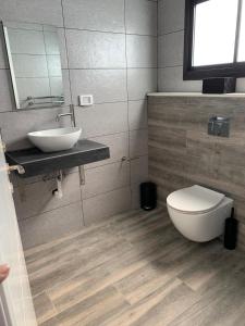 een badkamer met een wit toilet en een wastafel bij צמרת נופש in Rewaya