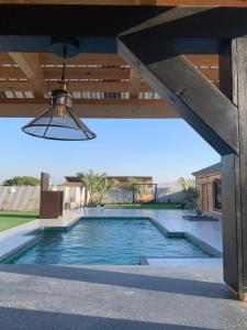 een zwembad onder een dak met een lichtarmatuur bij צמרת נופש in Rewaya