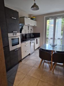 勒布伊Konos Suites Apartment in Puy-En-Velay的配有桌子和炉灶的厨房 顶部烤箱