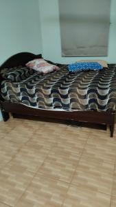 a bed in a room with a wooden floor at Homestay in Fujairah