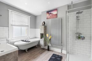 a white bathroom with a tub and a sink at The Quirk & Timber Retreat with Free parking in Brighton & Hove