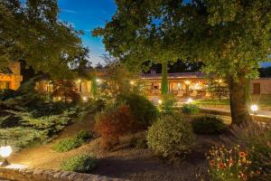 a building with lights in a garden at night at Les Hauteurs du Luberon in Caseneuve