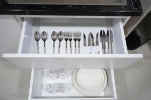 a white shelf with forks and spoons and silverware at Zenia Motel in Erbil