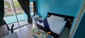 The Bedroom Kata Beach Phuket في شاطئ كاتا: غرفة نوم بها سرير وجدار أزرق