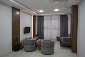 a waiting room with chairs and a table and a tv at Zenia Motel in Erbil