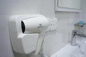a white hair dryer in a bathroom at Zenia Motel in Erbil +39 photos