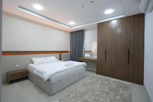 a bedroom with a bed and a wooden cabinet at Zenia Motel in Erbil