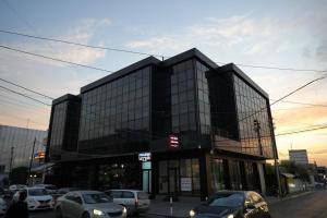 a black building with cars parked in front of it at Zenia Motel in Erbil