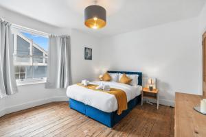 a bedroom with a large bed and a window at The Quirk & Timber Retreat with Free parking in Brighton & Hove