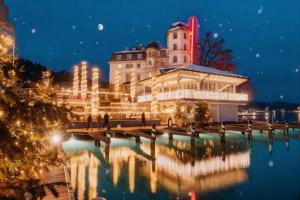 沃尔特湖畔佩莎赫施劳斯西菲尔斯酒店的一座晚上倒入水中的建筑