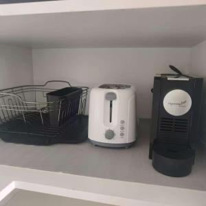 kuchenka mikrofalowa i toster na półce w obiekcie Galleria on the Glen - High floor deluxe apartment w mieście Glen Waverley