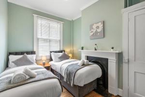 two beds in a room with green walls at The Quirk & Timber Retreat with Free parking in Brighton & Hove +24 photos