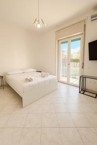 una camera bianca con un letto e una grande finestra di Room Raffinata Stile e Comfort a Salerno