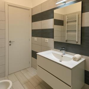 un bagno con lavandino, WC e specchio di Room Raffinata Stile e Comfort a Salerno Altre 15 foto