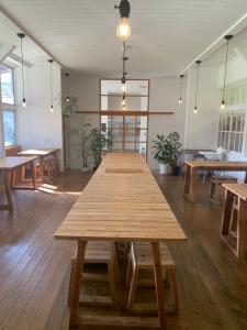 a large wooden table in a room with tables at 里山のいぶき舎 in Goto