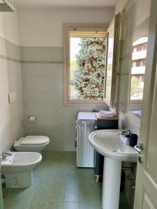 巴多利诺Grace House的带两个水槽、一个马桶和一扇窗户的浴室