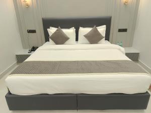 a bedroom with a large bed with white sheets and pillows at JBM resort & hotel in Jāmb