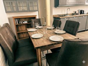 drewniany stół z krzesłami i kieliszkami do wina w obiekcie Coastal 3-Bed Flat near Lowestoft Beach w mieście Lowestoft