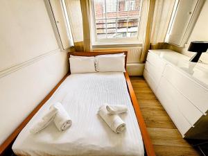 łóżko w małym pokoju z ręcznikami w obiekcie Coastal 3-Bed Flat near Lowestoft Beach w mieście Lowestoft