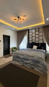 アクールにあるQuantum Havens Apartment - DUBAIのベッドルーム(大型ベッド1台、緑の椅子付)