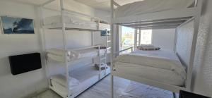 a room with four bunk beds and a television at Albergue Club Náutico de Águilas in Águilas