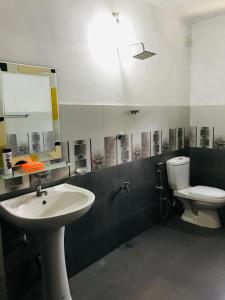 Un baño con lavabo, inodoro y espejo. en Lake View villa 2 BR near beach, en Tangalle