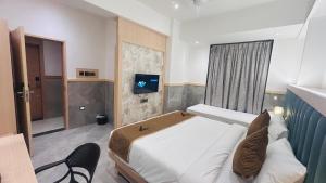 a bedroom with a bed and a television in it at Hotel Signature in Thane