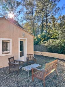 three wooden benches sitting in front of a building at La maison des Oiseaux in Trans-en-Provence +8 photos