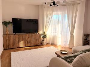 a living room with a flat screen tv on a entertainment center at ParkView in Craiova