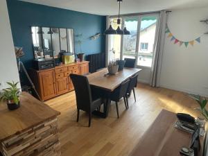 Un comedor con mesa y sillas de madera. en Grand T2 lumineux et cosy - 1min Termes Marlioz, en Aix-les-Bains
