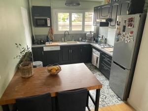 Una cocina con una mesa de madera y un refrigerador. en Grand T2 lumineux et cosy - 1min Termes Marlioz, en Aix-les-Bains