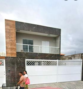 two people walking in front of a building at Bem praiana in Praia Grande