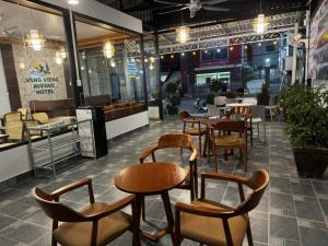 un ristorante con tavoli e sedie in una stanza di Avenue Hotel VangVieng a Vang Vieng
