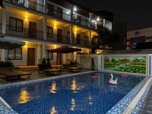 a swimming pool in front of a hotel at night at Avenue Hotel VangVieng in Vang Vieng