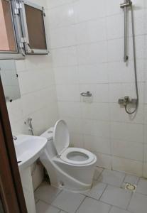 een witte badkamer met een toilet en een wastafel bij Chez Amina in Mbour