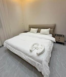 een slaapkamer met een groot bed met witte lakens bij Chez Amina in Mbour