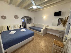 a bedroom with a blue bed and a mirror at Aperanto Galazio in Koufonisia