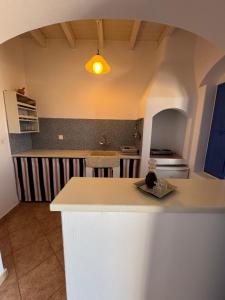a kitchen with a white island in a room at Aperanto Galazio in Koufonisia +7 photos
