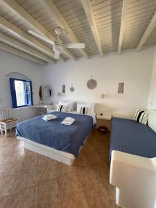 ein Schlafzimmer mit einem blauen Bett und einem Sofa in der Unterkunft Aperanto Galazio in Koufonisia